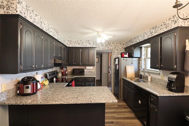 kitchen featuring sink, ceiling fan, a textured ceiling, light hardwood / wood-style floors, and stainless steel appliances