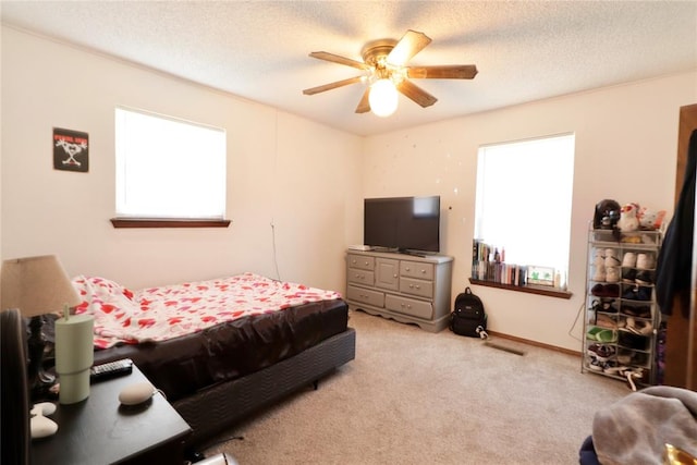 carpeted bedroom with ceiling fan and a textured ceiling