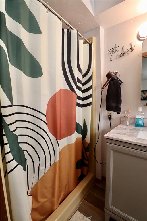 interior space with a shower with curtain and hardwood / wood-style flooring