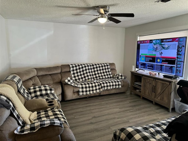 living room featuring ceiling fan, wood-type flooring, and a textured ceiling