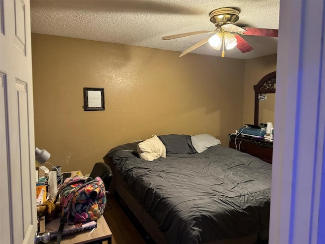 bedroom with ceiling fan, a textured ceiling, and hardwood / wood-style flooring