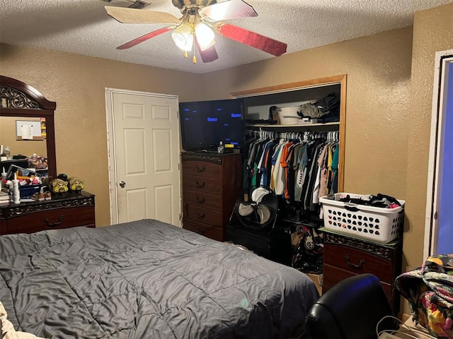 bedroom with ceiling fan, a closet, and a textured ceiling