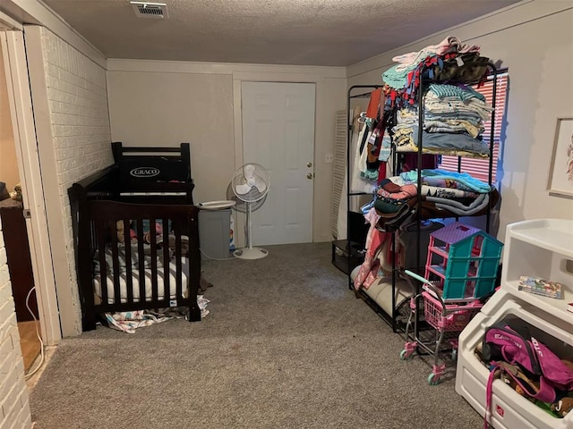 bedroom featuring carpet, a textured ceiling, brick wall, and a nursery area