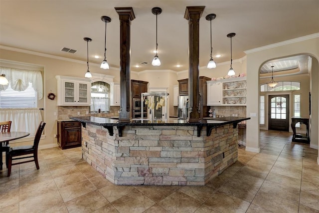 bar with a healthy amount of sunlight, crown molding, and backsplash