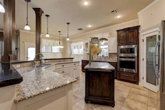 kitchen with ornamental molding, stainless steel appliances, sink, pendant lighting, and a large island