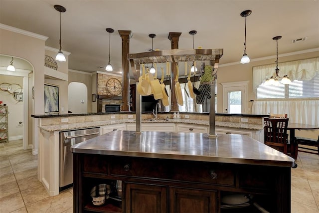 kitchen featuring stainless steel dishwasher, an island with sink, pendant lighting, dark brown cabinets, and ornamental molding