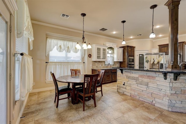 dining area featuring ornate columns and ornamental molding