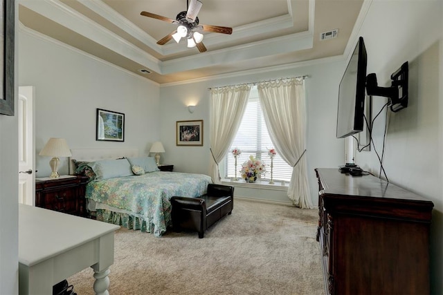 carpeted bedroom featuring a tray ceiling, ceiling fan, and ornamental molding