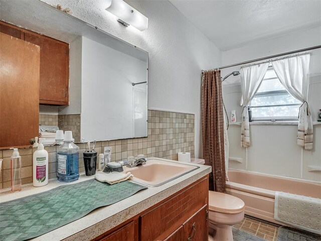 full bathroom with backsplash, shower / tub combo with curtain, vanity, and toilet