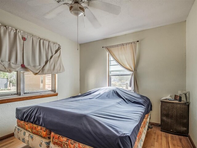 bedroom featuring a textured ceiling, light hardwood / wood-style flooring, and ceiling fan