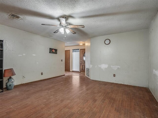 spare room featuring hardwood / wood-style flooring, ceiling fan, and a textured ceiling