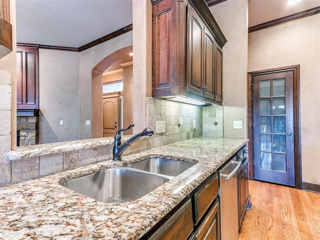 kitchen with sink, stainless steel dishwasher, backsplash, crown molding, and light hardwood / wood-style floors