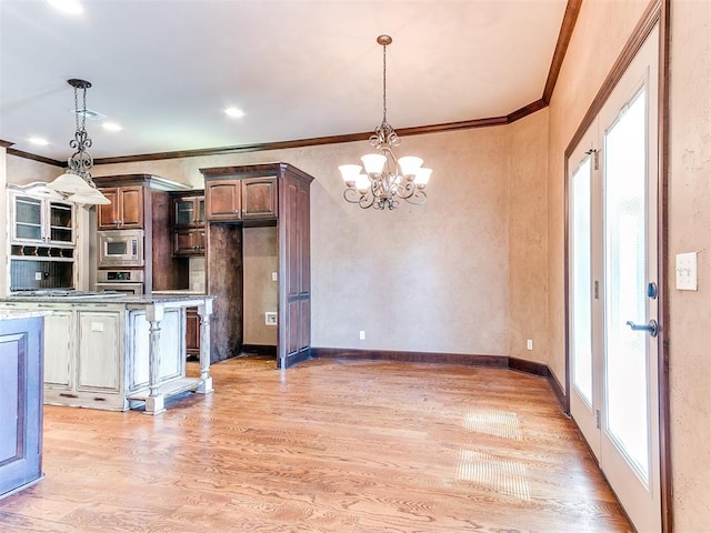 kitchen featuring a notable chandelier, ornamental molding, hanging light fixtures, and appliances with stainless steel finishes