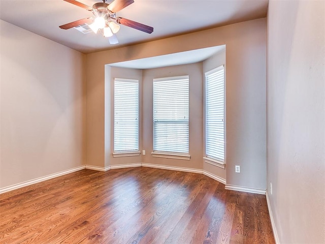 unfurnished room with ceiling fan and dark wood-type flooring