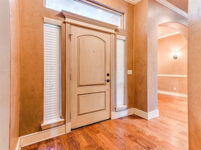 entrance foyer with light hardwood / wood-style floors and crown molding