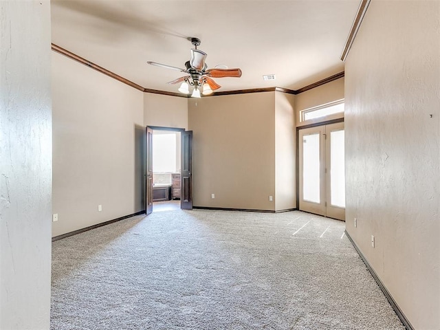 carpeted empty room with ceiling fan and crown molding