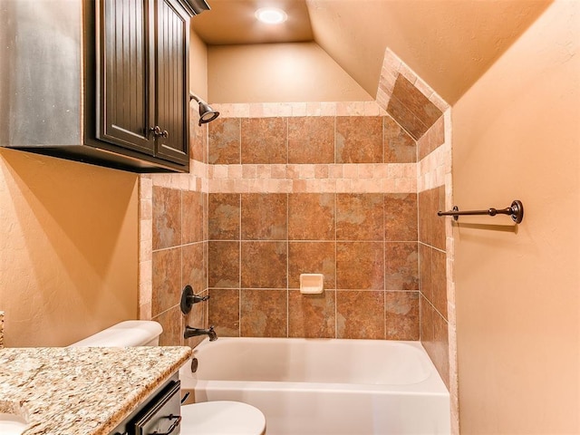 full bathroom featuring vanity, tiled shower / bath combo, and toilet