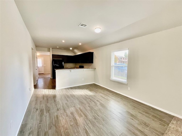 unfurnished living room with dark wood-type flooring and vaulted ceiling