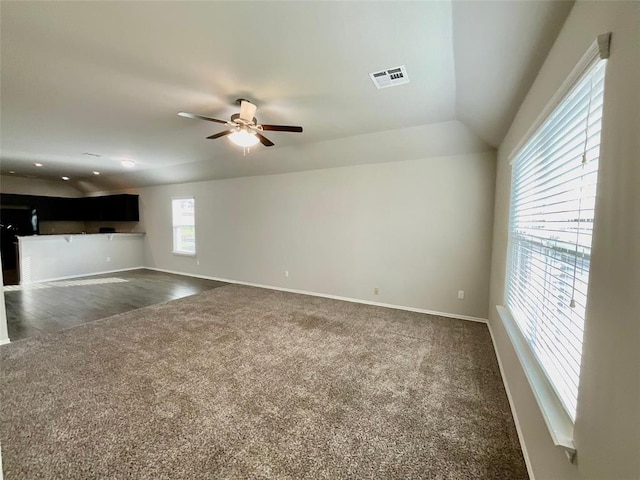 unfurnished living room featuring dark carpet, ceiling fan, and lofted ceiling