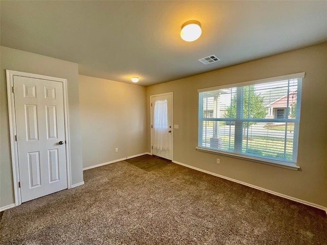 spare room with dark colored carpet