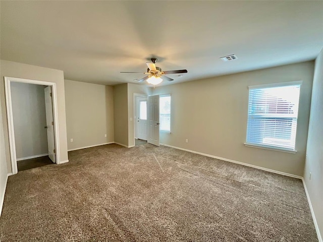 unfurnished bedroom with carpet, ceiling fan, and multiple windows