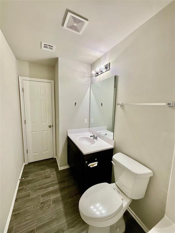 bathroom featuring vanity, toilet, and wood-type flooring