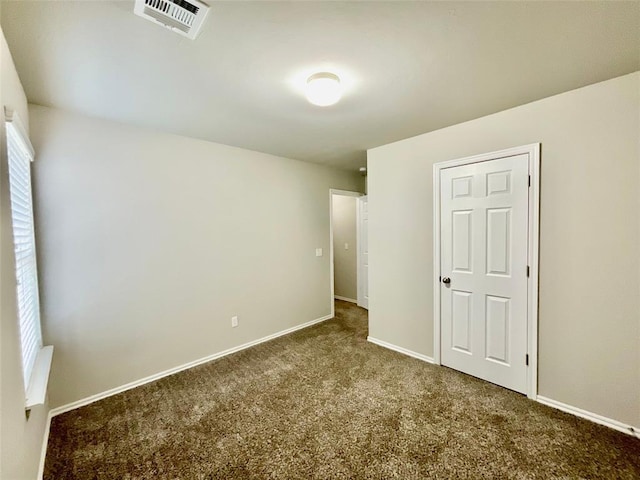 unfurnished bedroom featuring a closet and dark colored carpet