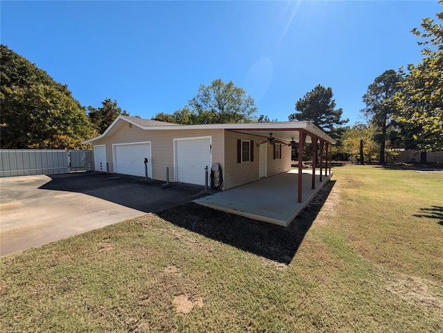 exterior space featuring an outbuilding, a yard, a garage, and ceiling fan