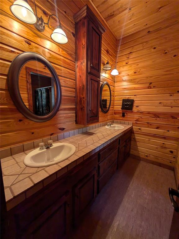 bathroom with vanity, hardwood / wood-style flooring, wood walls, and wood ceiling