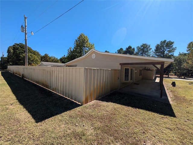 view of home's exterior with a lawn and a carport