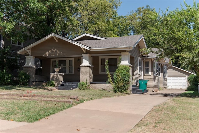 craftsman house featuring a porch, a garage, an outdoor structure, and a front lawn