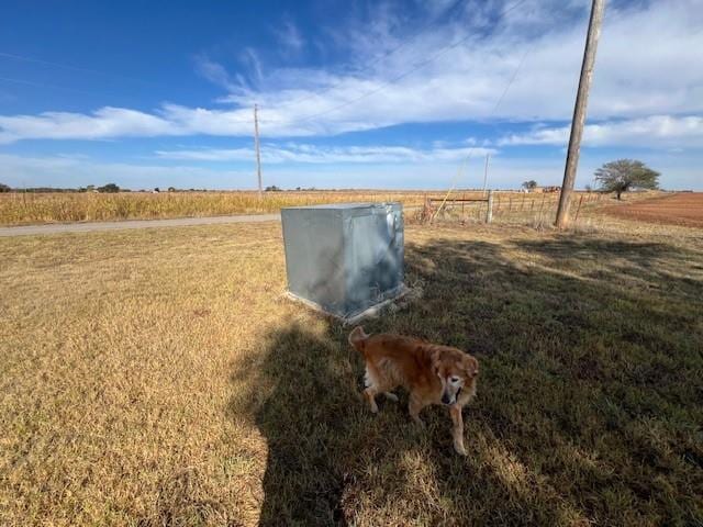 entry to storm shelter featuring a yard and a rural view