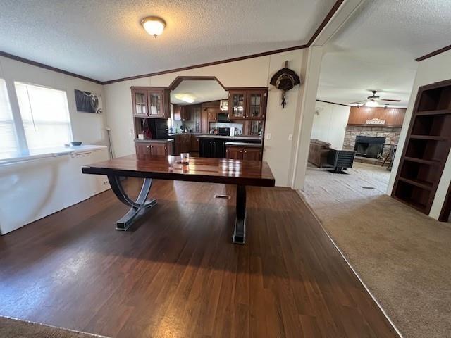 dining area featuring dark colored carpet, a textured ceiling, ceiling fan, and lofted ceiling