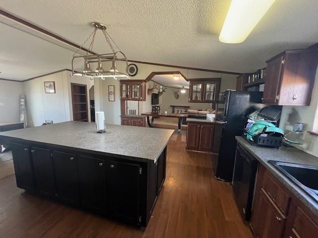 kitchen with a center island, black appliances, dark hardwood / wood-style floors, a textured ceiling, and decorative light fixtures