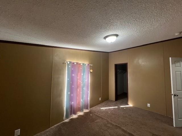 carpeted empty room featuring a textured ceiling