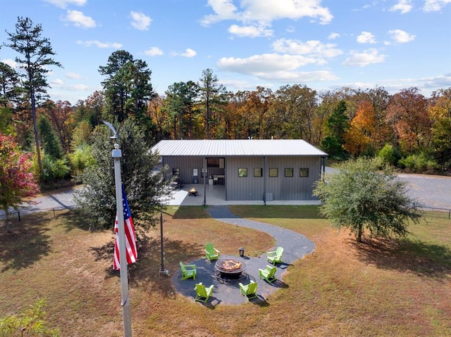 view of front of house with a front yard, an outdoor fire pit, and an outdoor structure