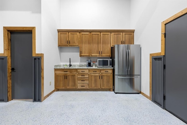 kitchen with appliances with stainless steel finishes and light stone counters