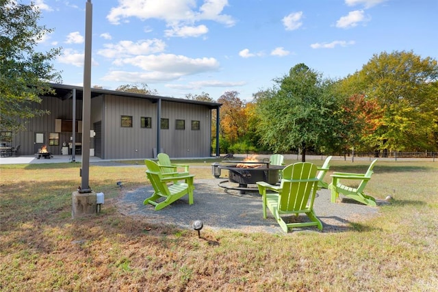 view of yard with an outdoor structure and a fire pit