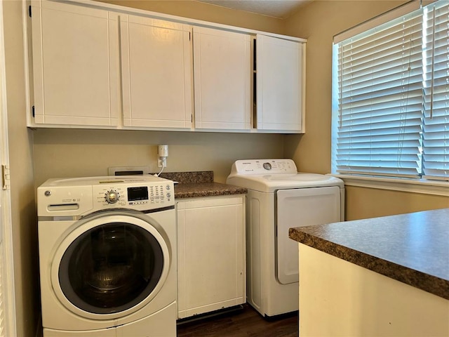 laundry room with cabinets, dark wood-type flooring, and washing machine and clothes dryer