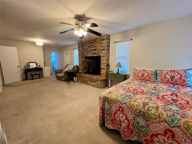 carpeted bedroom featuring ceiling fan, a wood stove, and multiple windows