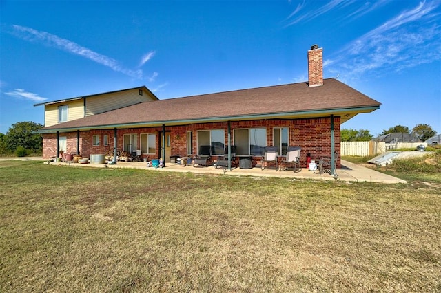 rear view of property featuring a lawn and a patio