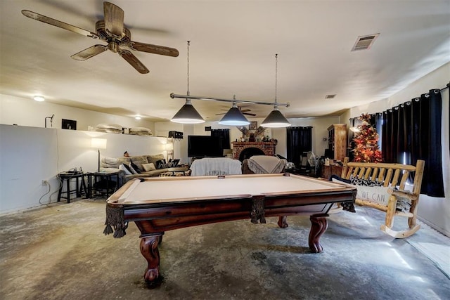 rec room with a brick fireplace, ceiling fan, concrete floors, and pool table