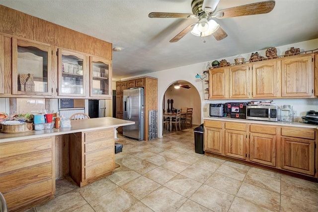 kitchen with ceiling fan, light tile patterned flooring, and stainless steel appliances