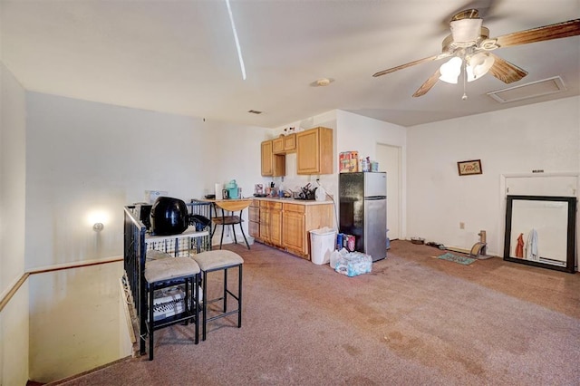 kitchen with carpet, ceiling fan, light brown cabinetry, and stainless steel refrigerator