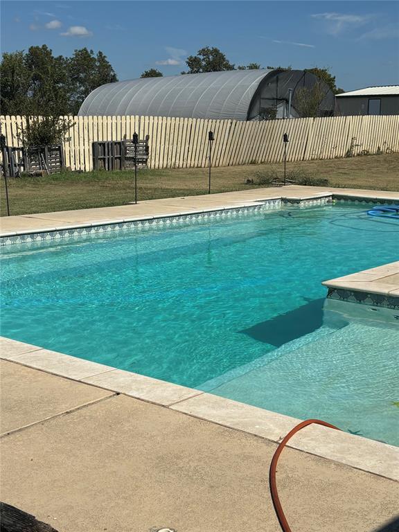 view of swimming pool featuring a yard