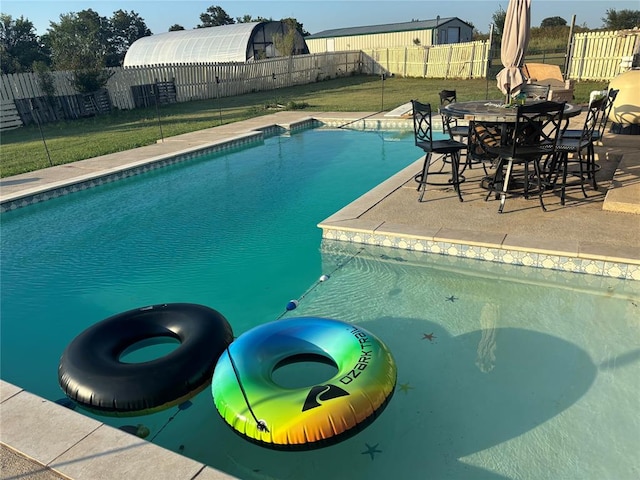 view of pool featuring a lawn and a patio area