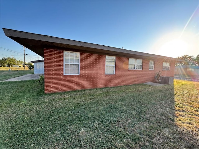 view of side of home with a yard and cooling unit