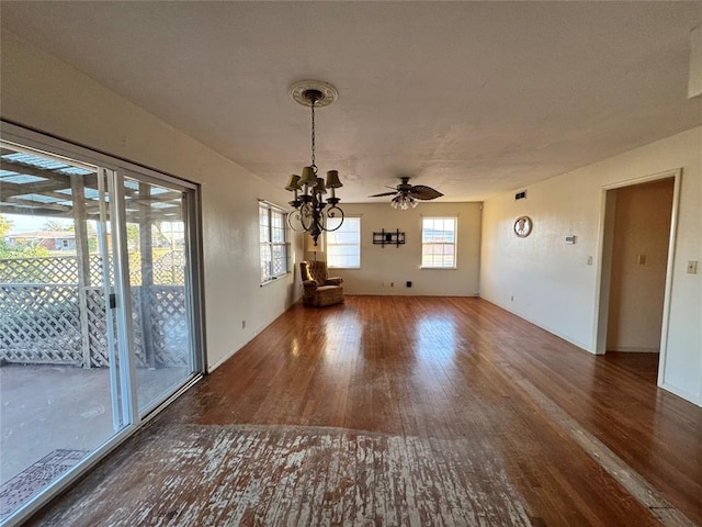 spare room featuring ceiling fan with notable chandelier and dark hardwood / wood-style floors