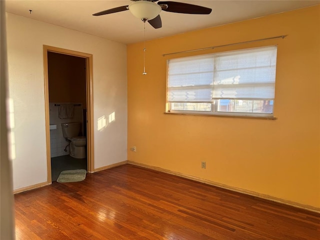 unfurnished bedroom with hardwood / wood-style flooring, ceiling fan, and ensuite bathroom