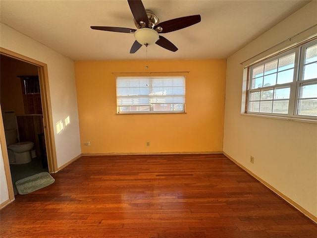 empty room with ceiling fan and dark wood-type flooring